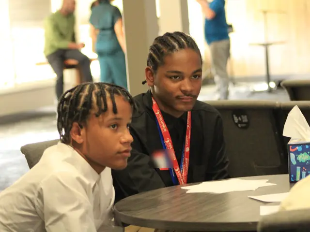 Two students listening during a session at the summit