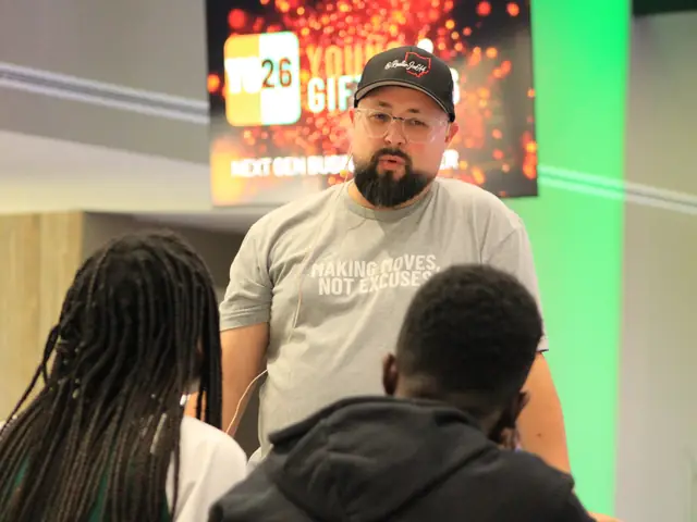 A speaker talking with students at their table