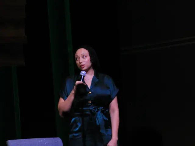 A speaker addressing the room with a microphone